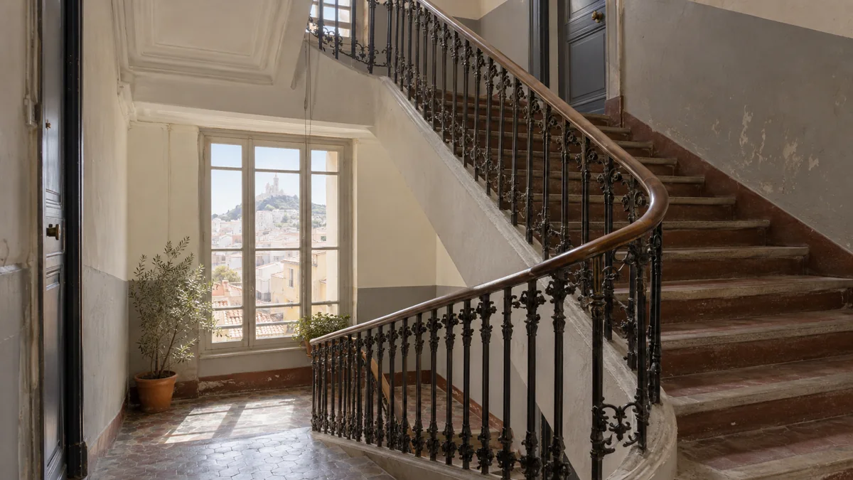 Cage d'escalier ancienne d'une copropriété avec traces d'usage visibles